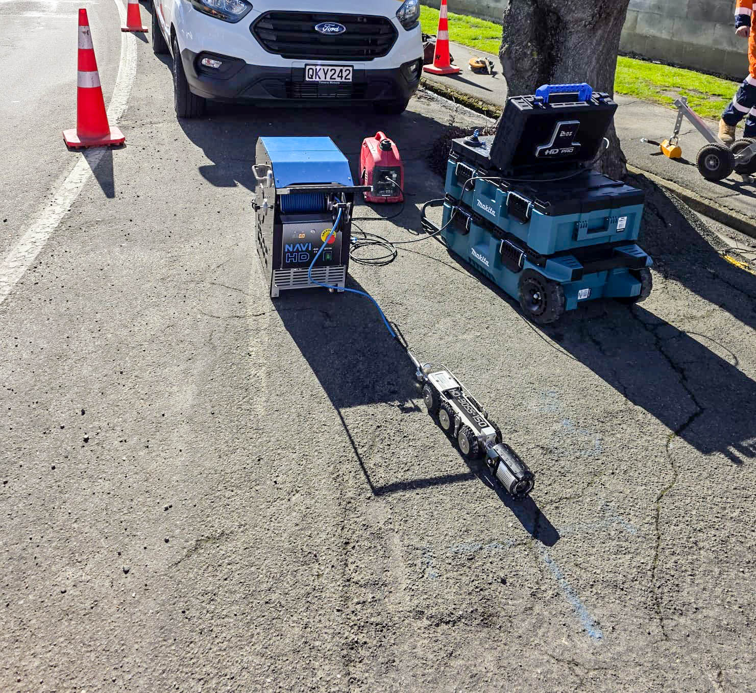 CCTV crawler camera and control unit set up on a road beside a service van